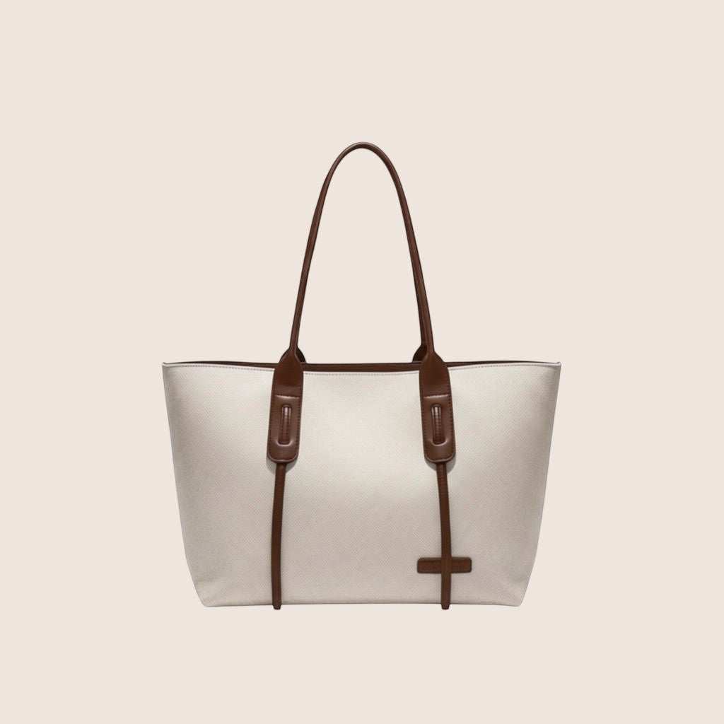 Norielle cream canvas tote bag with black leather trim and handles. Casual, all-match style.